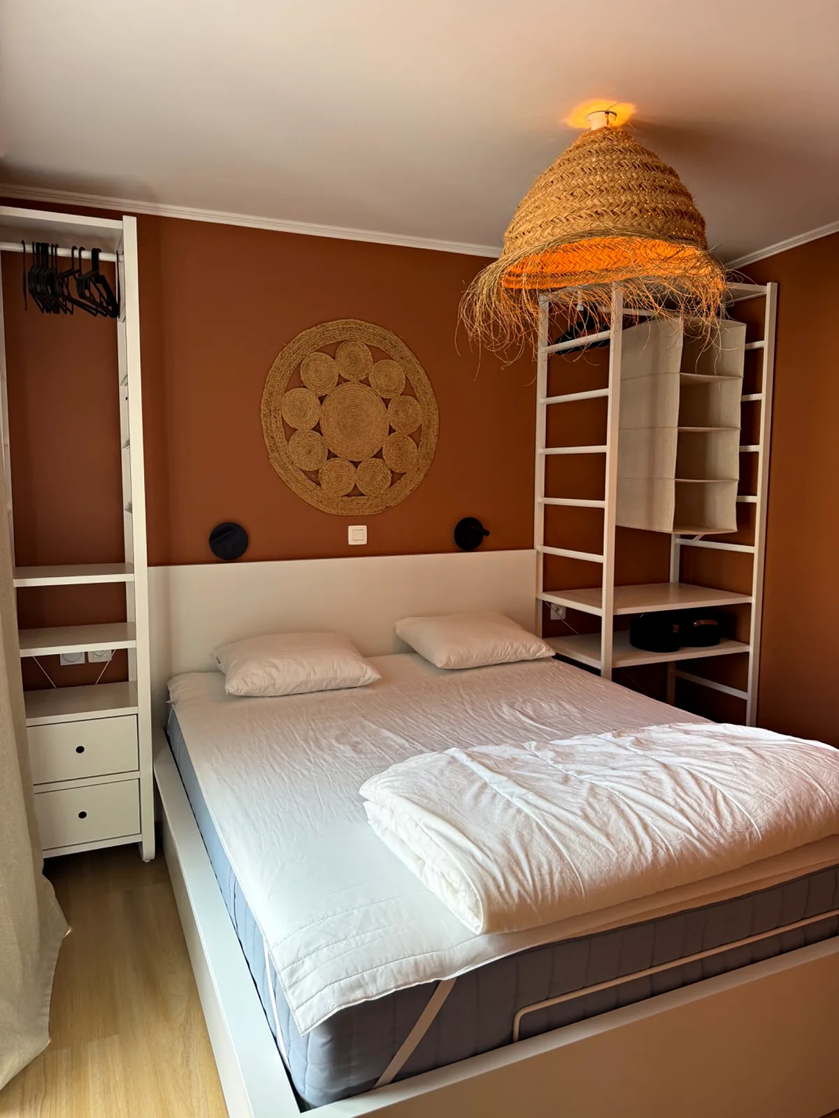 Chambre terracotta avec lit double et penderie