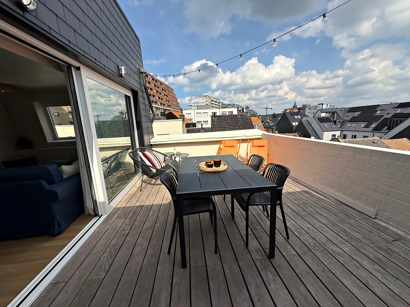 Table extérieure devant la baie vitrée ouverte sur le séjour